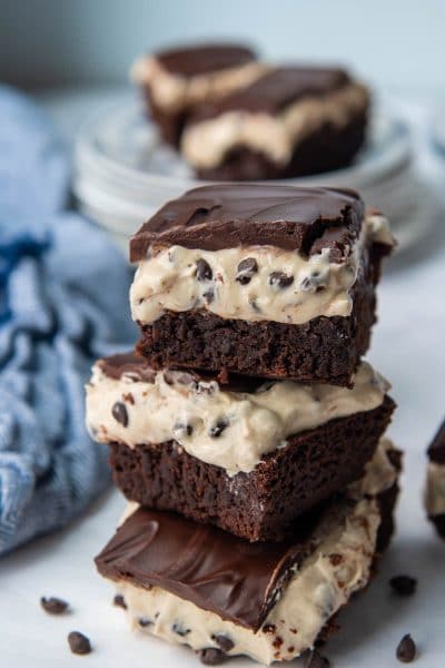 a stack of three brownies with a blue towel in the background