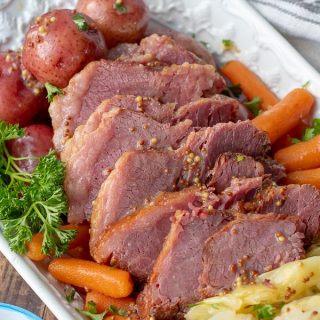 an overhead shot of a platter of slow cooker corned beef and cabbage with potatoes and carrots