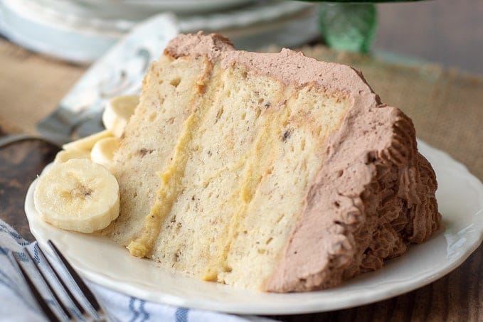 a slice of fluffy banana cake with banana filling on a white plate