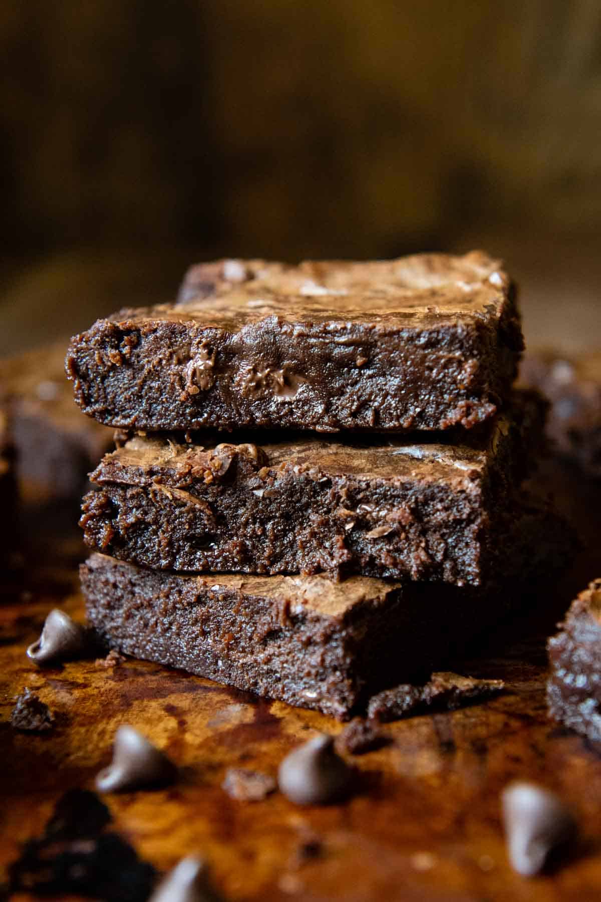 a stack of brownies with chocolate chips around.