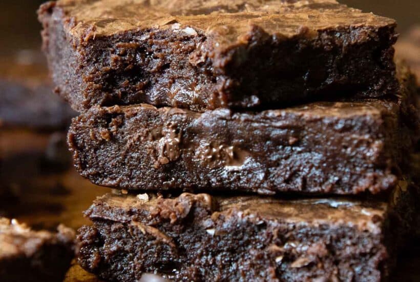 a stack of brownies with a bite taken out of top one.