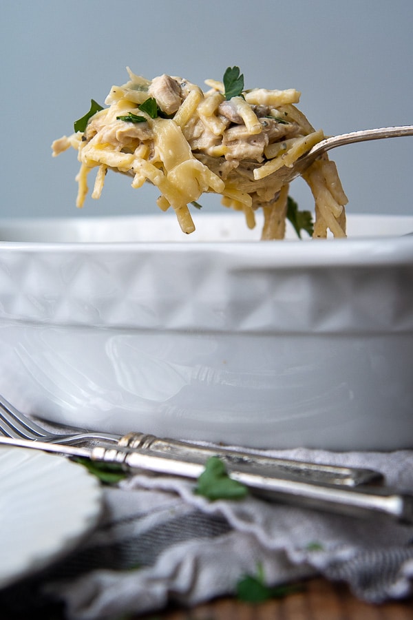 a serving of tetrazzini being lifted from a casserole dish