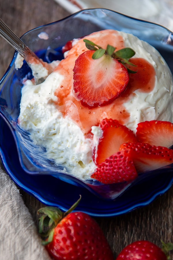 a serving sized dish with creme a la creme in it strawberries and fruit sauce