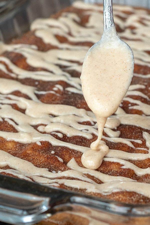 a spoon pouring glaze over snickerdoodle bars