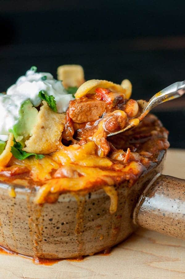 a bowl of chorizo chicken chili with a spoon pulling out a bite
