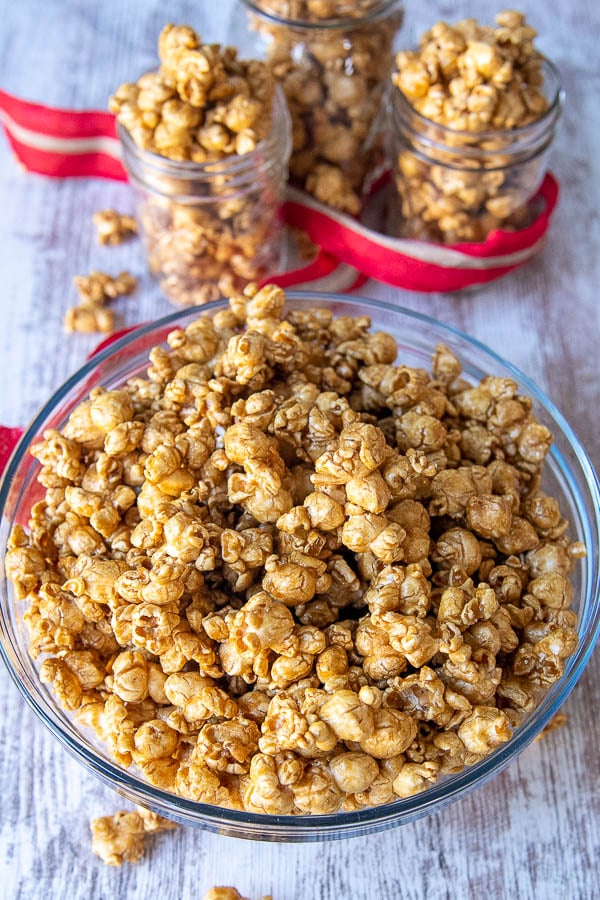 a bowl of microwave caramel corn with smaller jars around it