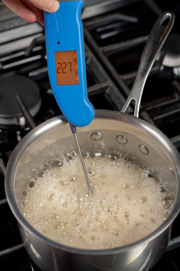 a candy thermometer measuring the temperature of peanut brittle