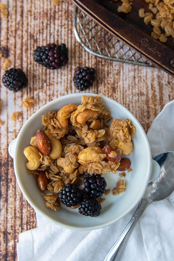 a bowl of homemade granola with milk and berries