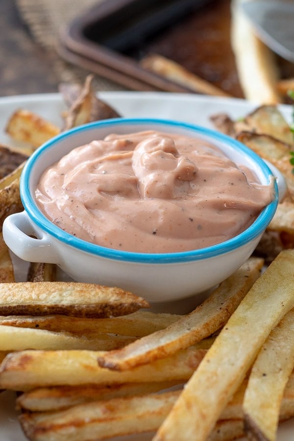 a close up shot of fry sauce on a plate of oven fries