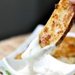 a roasted ranch potato being dipping into ranch dressing