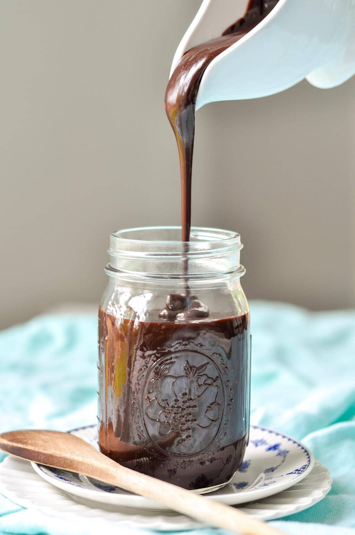 hot fudge sauce being poured into a glass jar