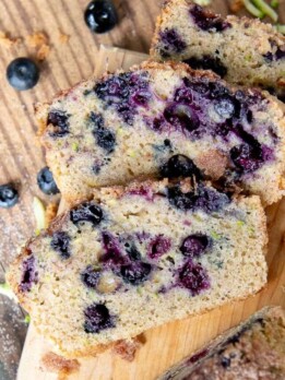 overhead shot of slices of blueberry zucchini bread on a cutting board