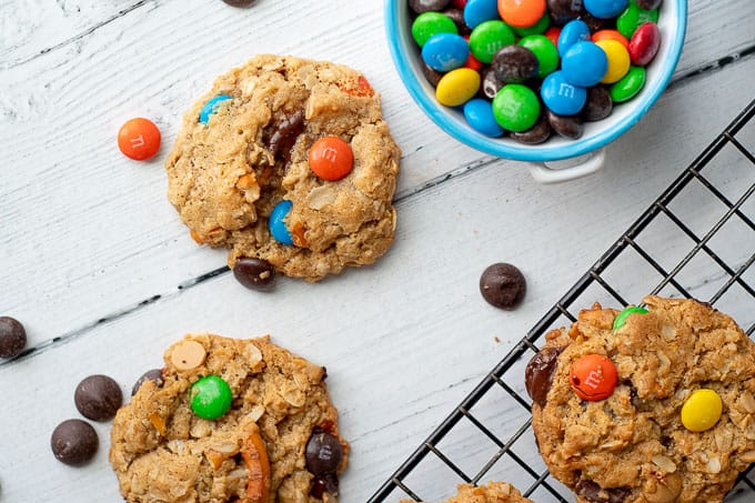 kitchen sink cookies on a cooling rack with a bowl of m&ms nearby