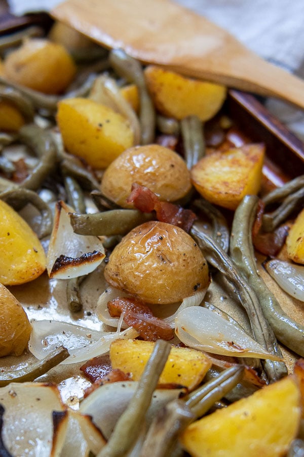 close up of green beans and potatoes on a baking sheet