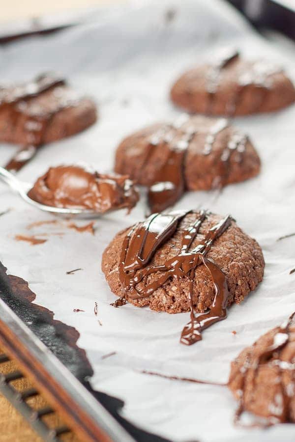 an easy Nutella cookie with chocolate drizzled over the top sitting on a cookie sheet