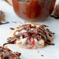 chocolate coconut macaroon on a baking sheet with chocolate drizzled over top