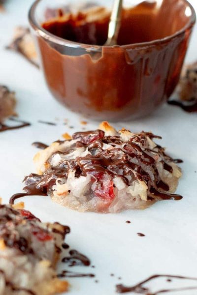 chocolate coconut macaroon on a baking sheet with chocolate drizzled over top