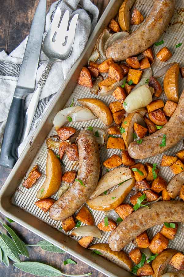 overhead shot of a sheet pan sausage bake with sweet potatoes, onions, and pears 