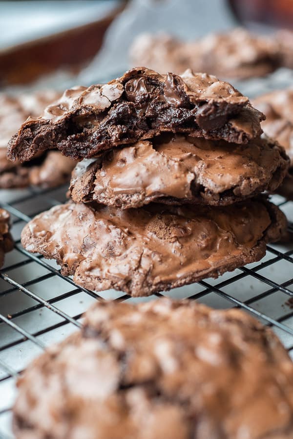 a stack of flourless chocolate cookies on a cooling rack