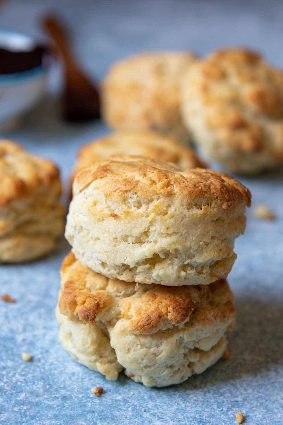 a stack of two gluten free biscuits with more biscuits laying around them