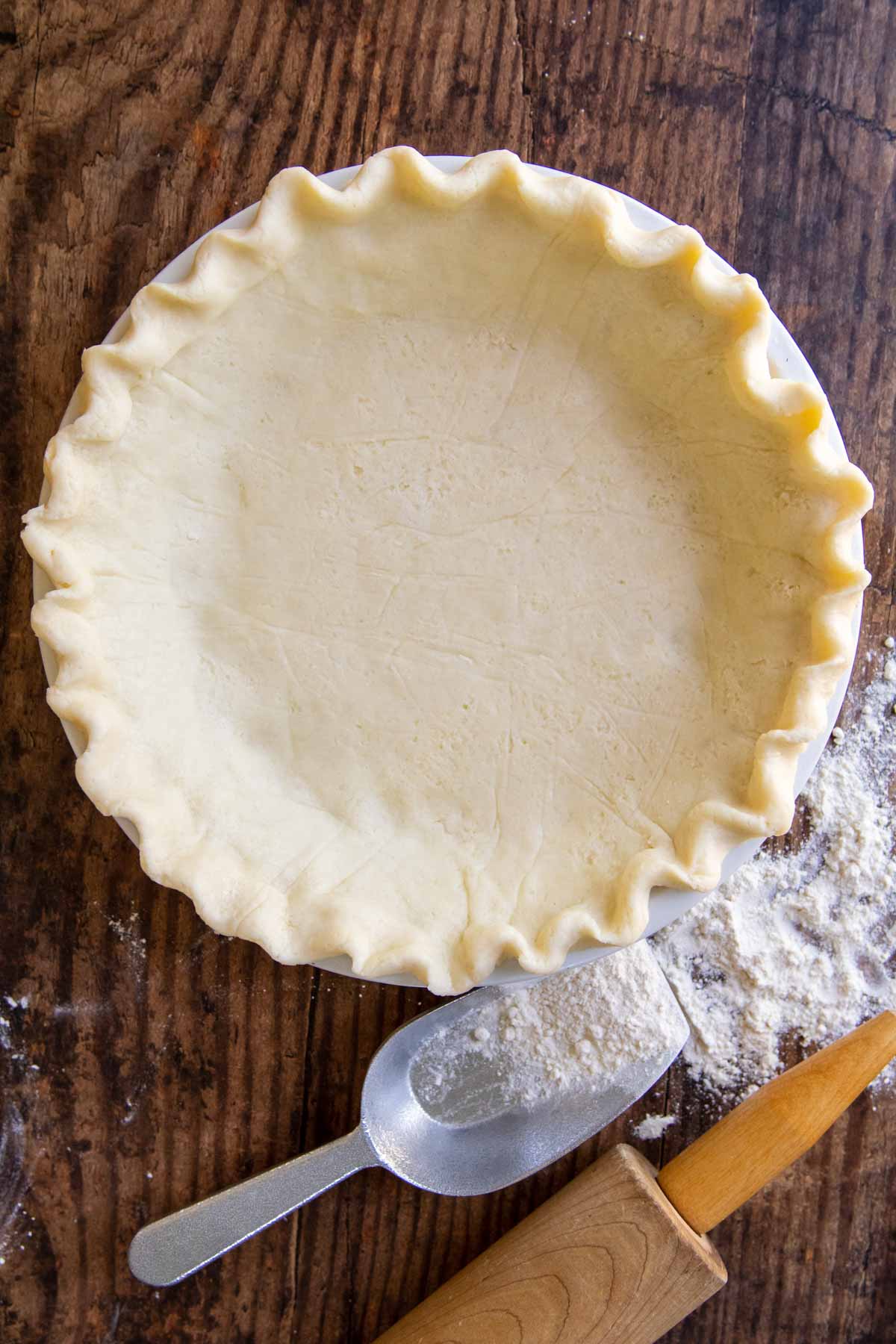 overhead shot of gluten-free pie crust with flour and rolling pin next to it