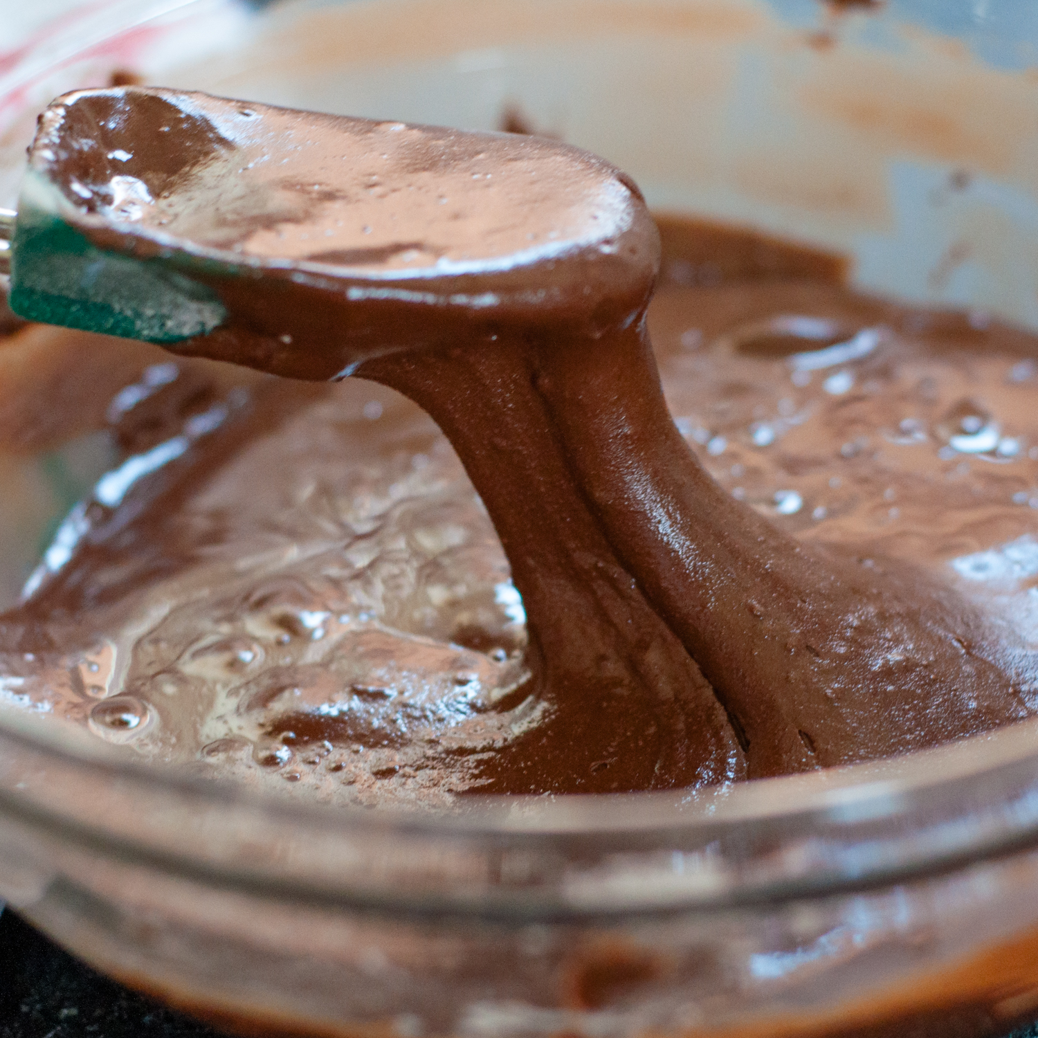 a spoon coming out of the batter bowl.