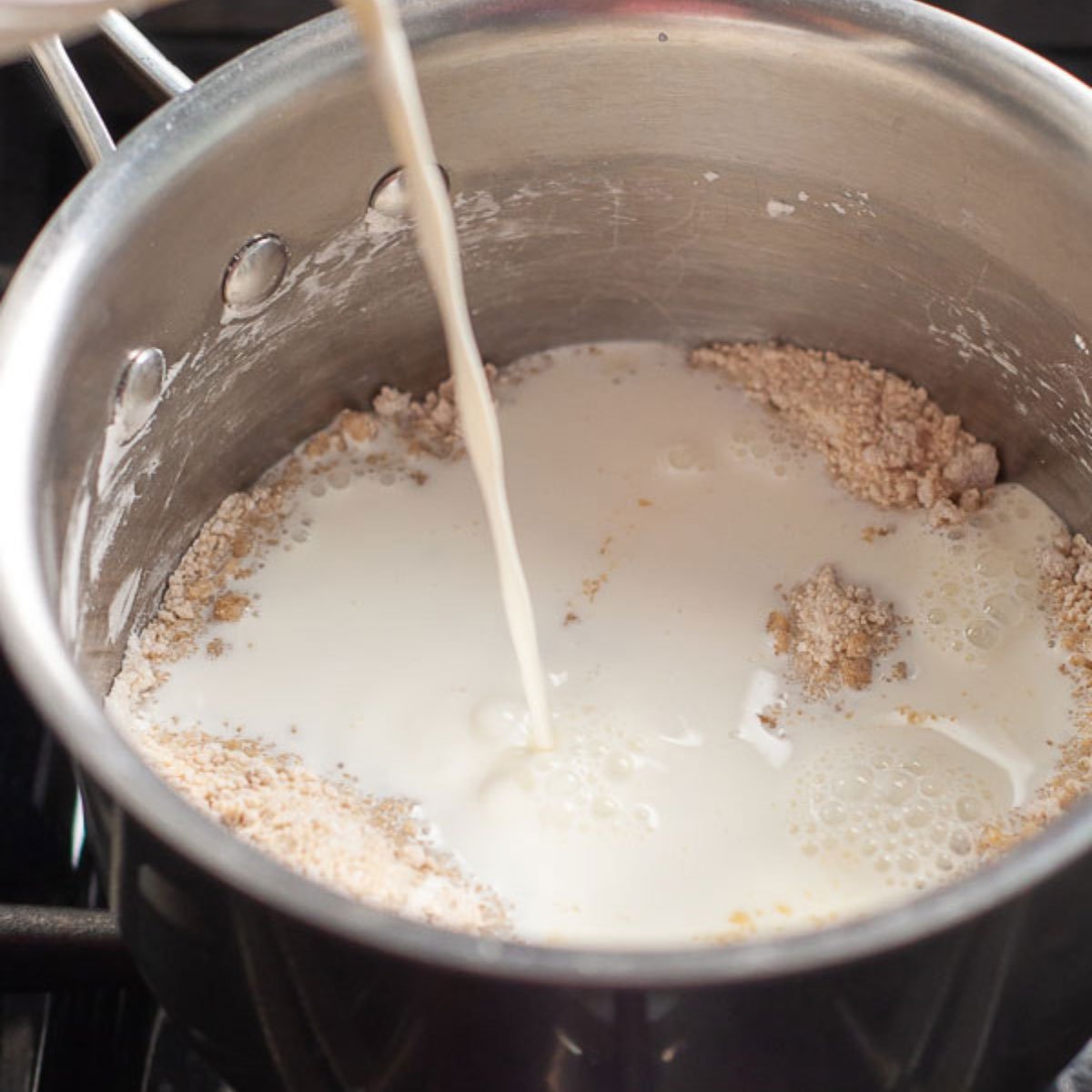 milk being poured into dry ingredients.