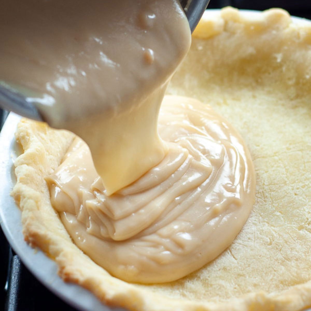 the custard being poured into the partially baked crust.