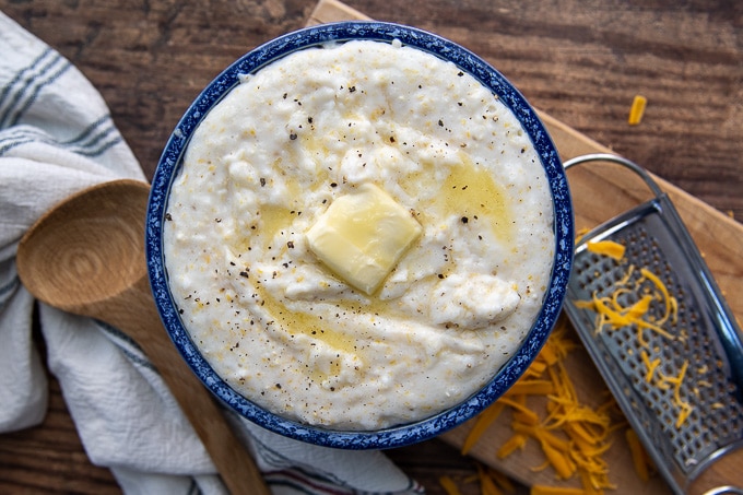 overhead shot of grits in a blue bowl with butter on top