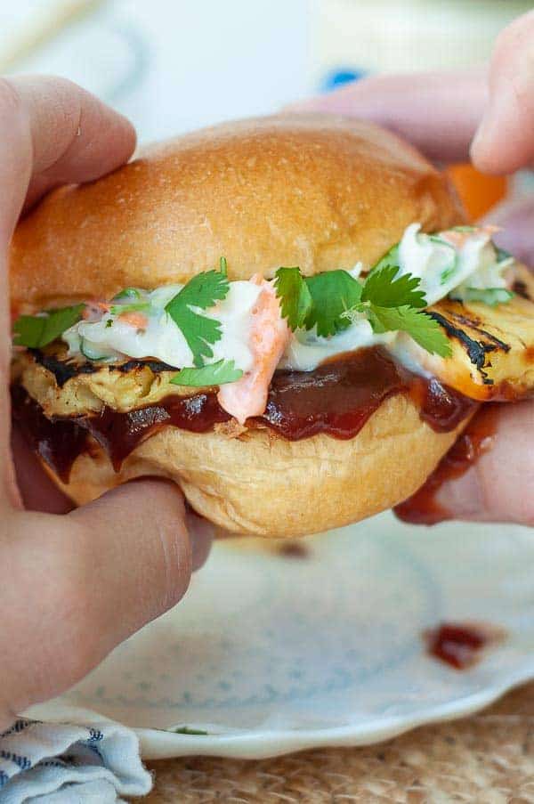 two hands holding up a BBQ pulled chicken sandwich