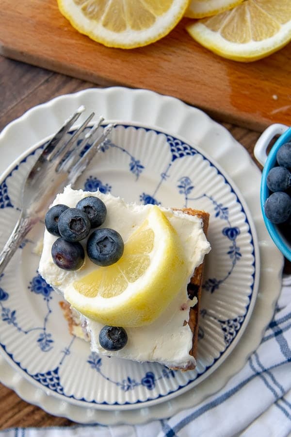 an overhead shot of lemon blueberry cake with a bite taken out and a fork resting on the plate