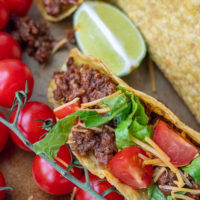 close up of beef taco with tomatoes, cheese, and lettuce
