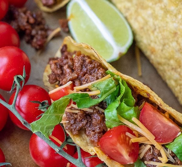 close up of beef taco with tomatoes, cheese, and lettuce