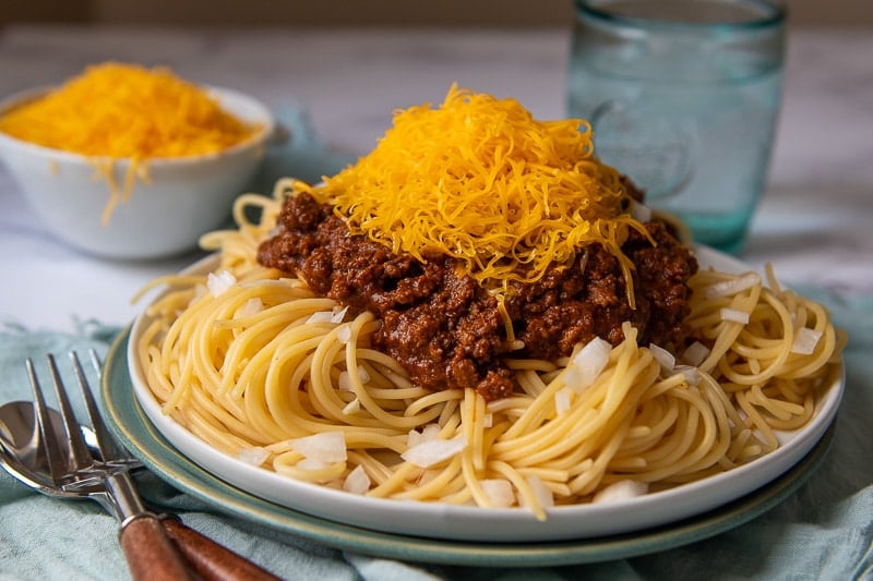 a plate of skyline chili on spaghetti with lots of cheese on top