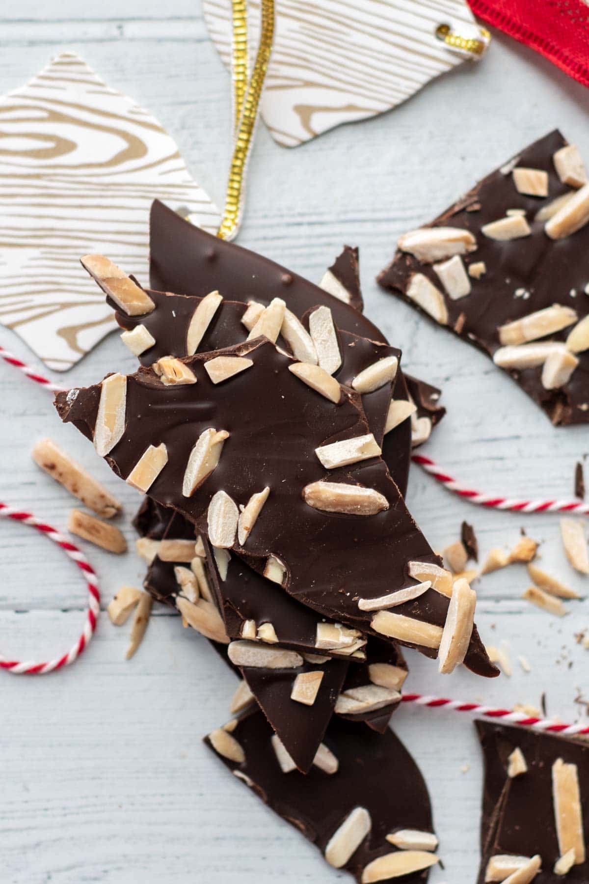 overhead shot of almond chocolate bark with gift tags around