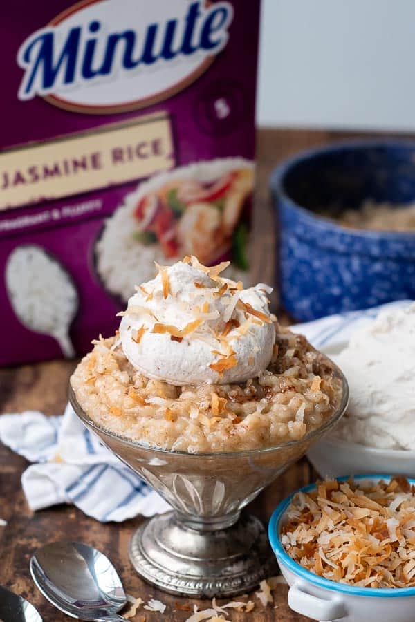 a small serving dish of coconut rice pudding with whipped cream and toasted coconut on top