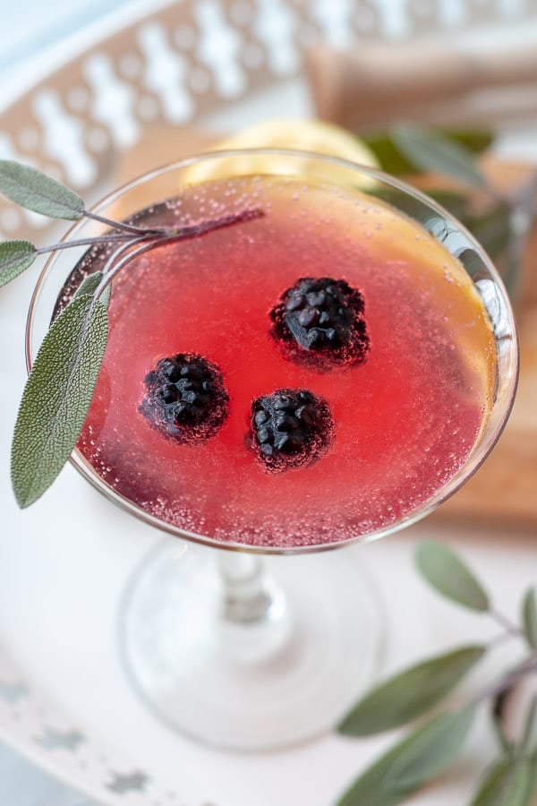 an overhead shot of a blackberry martini with a sage leaf resting on top