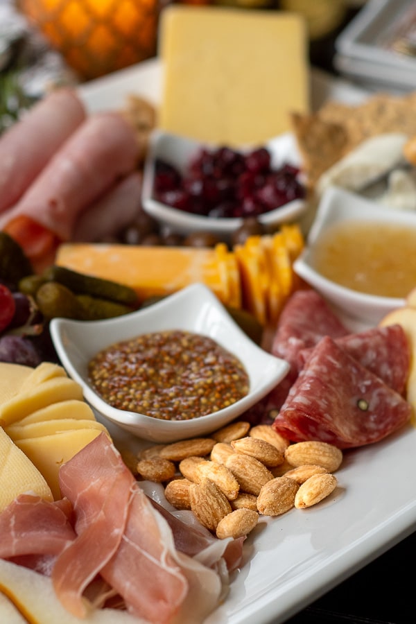 a charcuterie board close up with meats, cheeses, and nuts