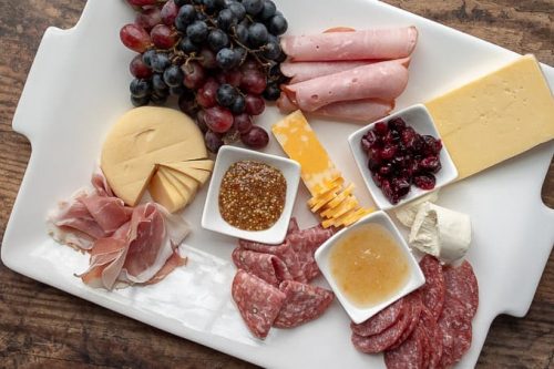 third step of how to make a charcuterie board - adding meats