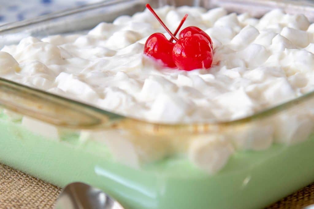 lime jello salad in a glass dish with marshmallows on top