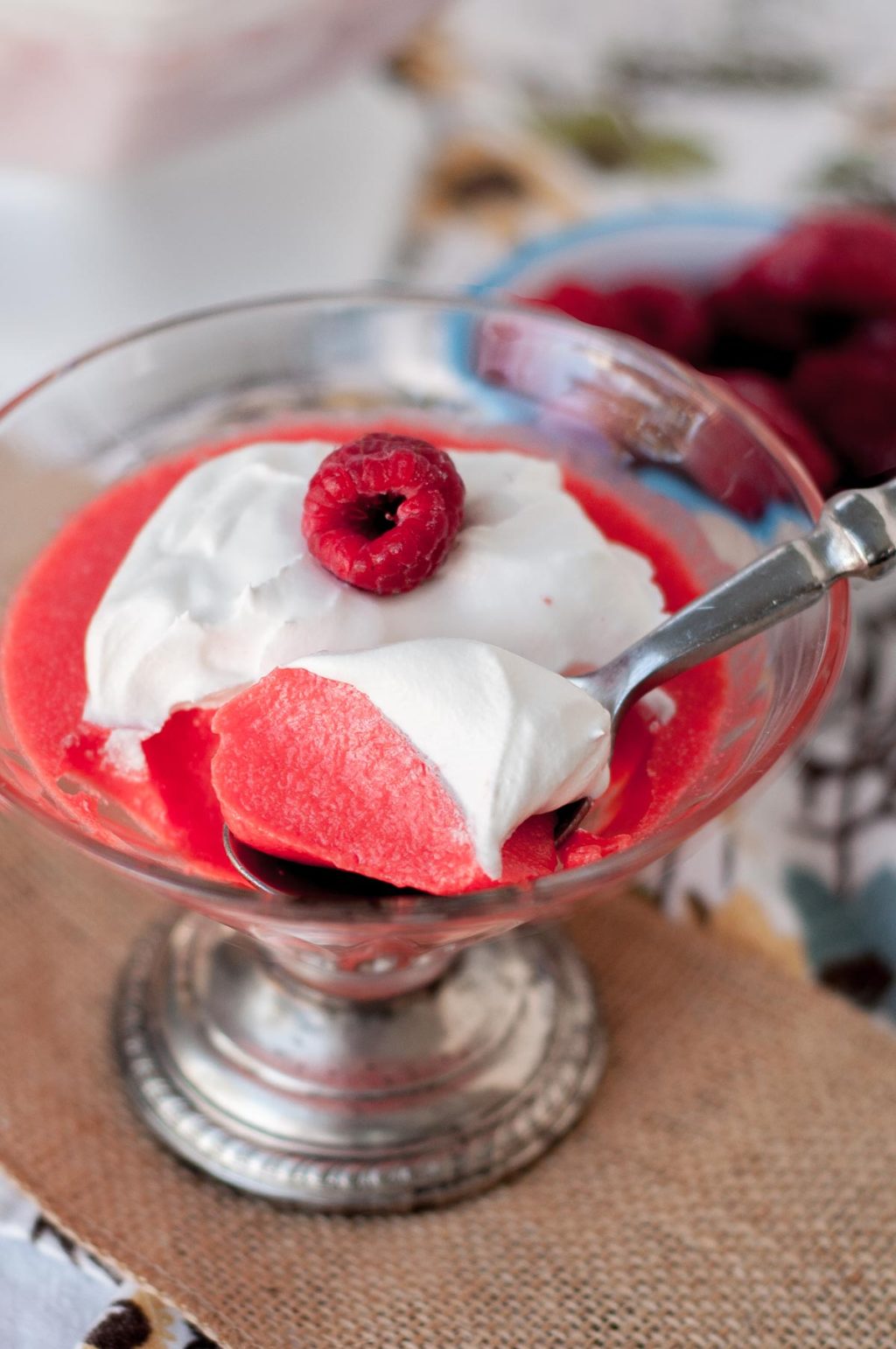 a spoon taking out a bite of creamy raspberry jello with cool whip on top