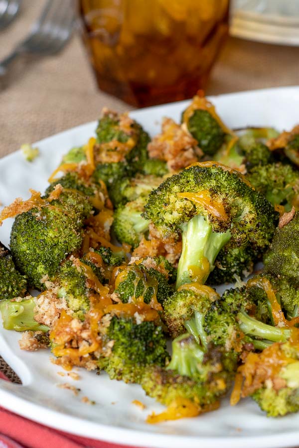 a pile of baked broccoli and cheese on a white serving dish