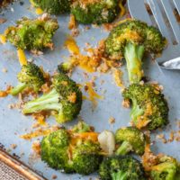 a close up shot overhead of baked broccoli and cheese on a baking sheet