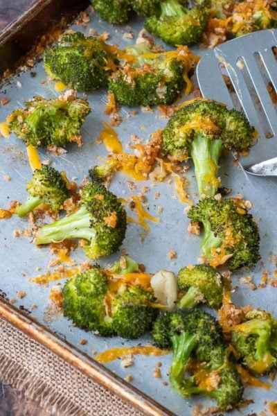 a close up shot overhead of baked broccoli and cheese on a baking sheet