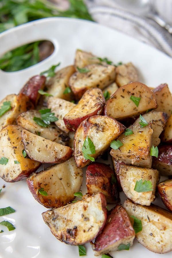 a close up of grilled potatoes on a white plate