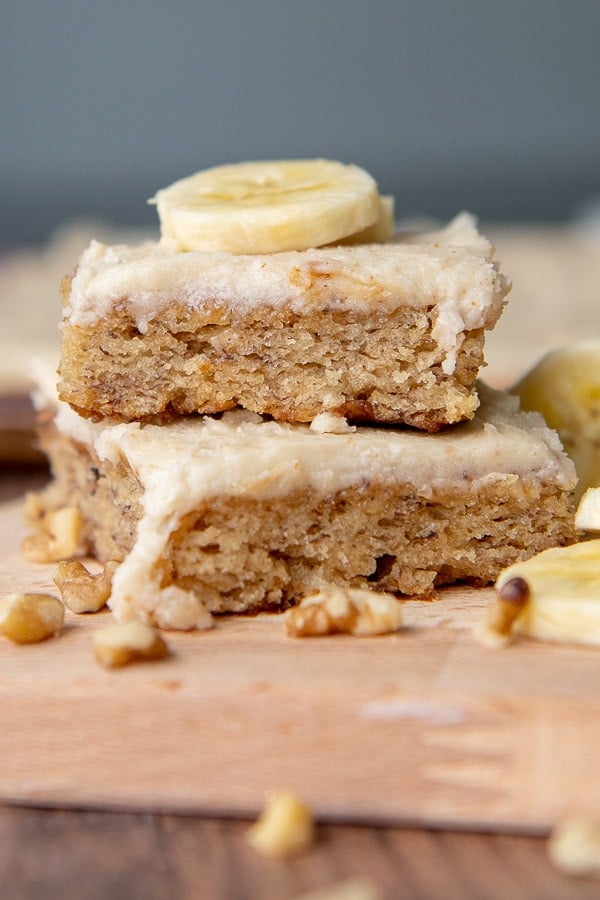 a stack of two banana bars with a sliced banana piece on top