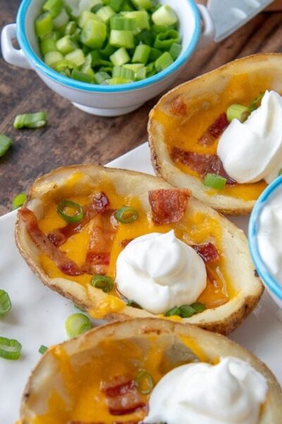 a close up of a loaded potato skin with a dollop of sour cream on top