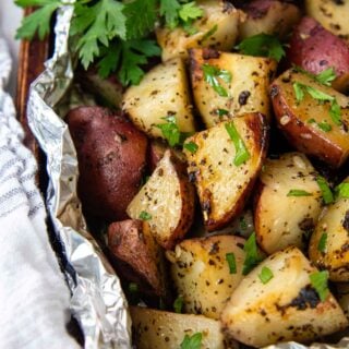 grilled red potatoes in foil with fresh parsley.