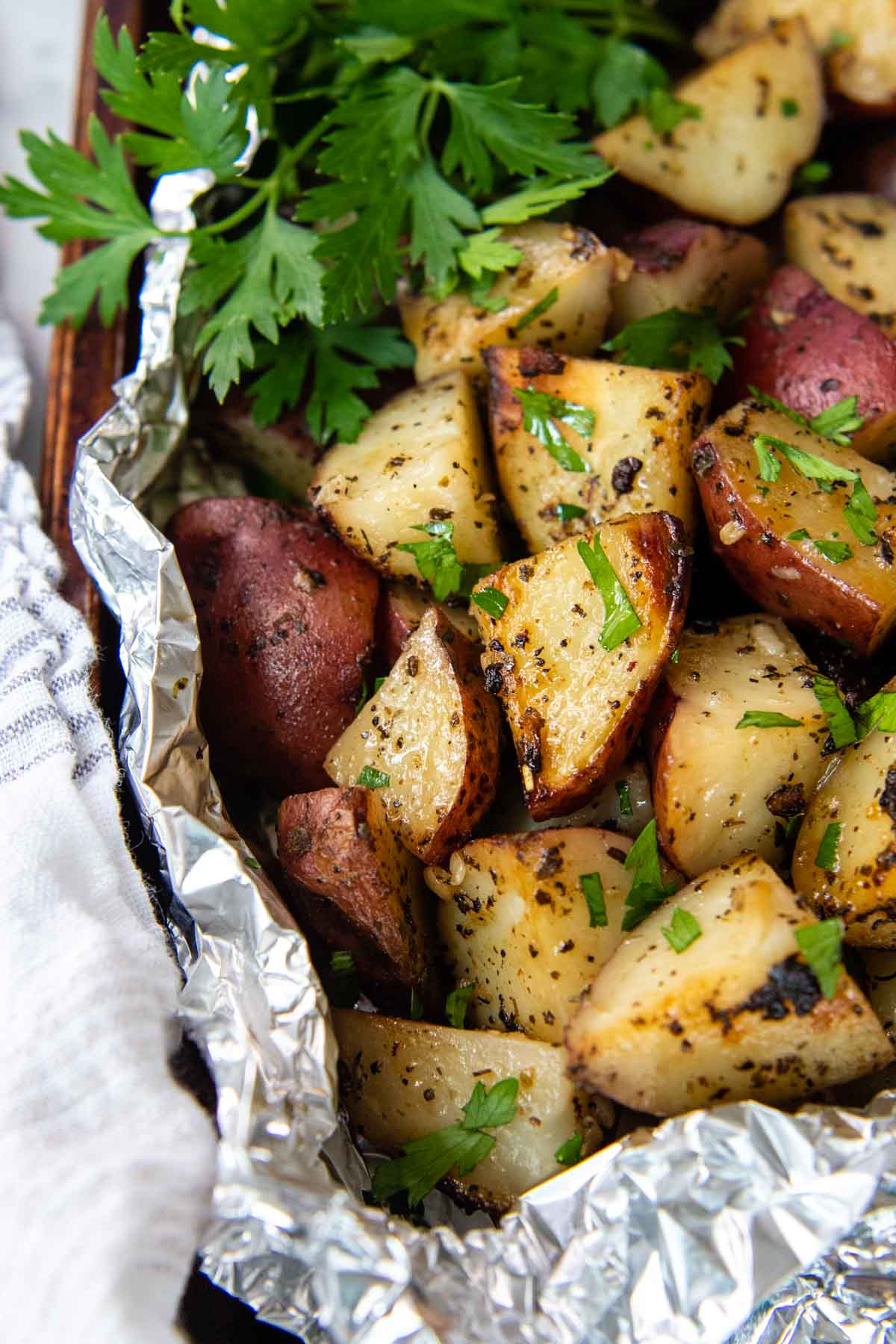 grilled red potatoes in foil with fresh parsley.