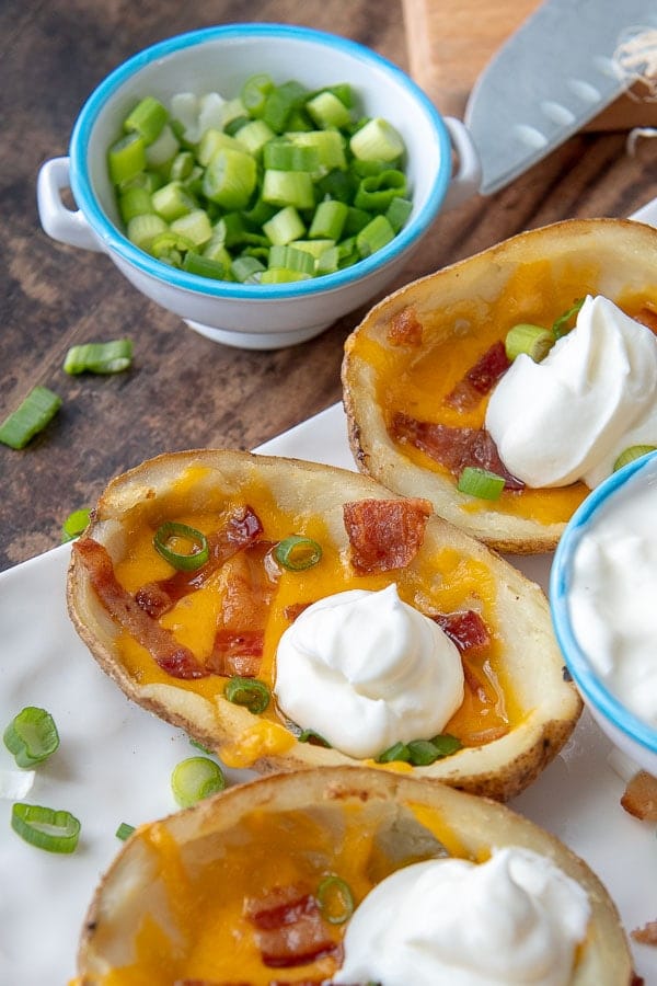 a close up of a loaded potato skin with a dollop of sour cream on top 